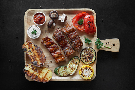 Barbecue Pork Ribs with vegetables on cutting board top viewの写真素材
