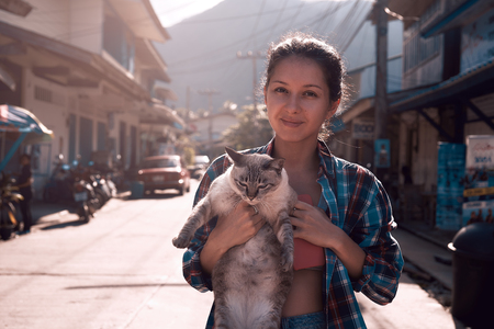 cute young woman with cat outdoorsの写真素材