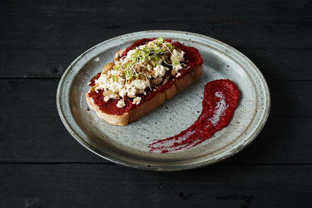 Beetroot humus with toast, chickpea and sesame seeds over wooden surface, top viewの写真素材