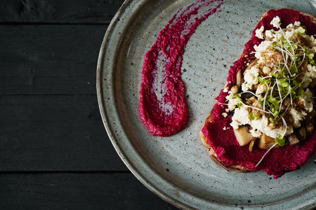 Beetroot humus with toast, chickpea and sesame seeds over wooden surface, top viewの写真素材