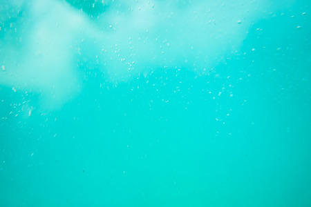 background image of blue water surface, blue sea, bubblesの写真素材