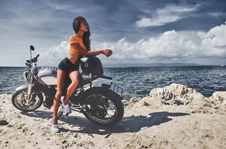 sexy asian woman near her vintage custom motorcycleの写真素材