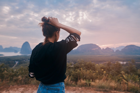 Rear view of a young woman enjoying the awesome view of Ao Phang Nga National Parkの写真素材