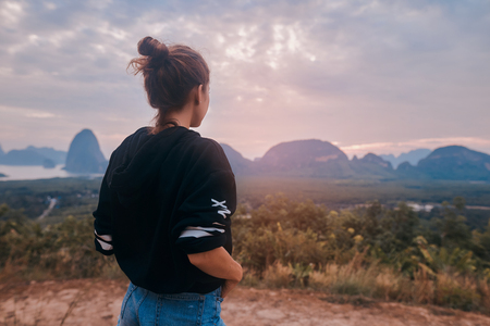 Rear view of a young woman enjoying the awesome view of Ao Phang Nga National Parkの写真素材