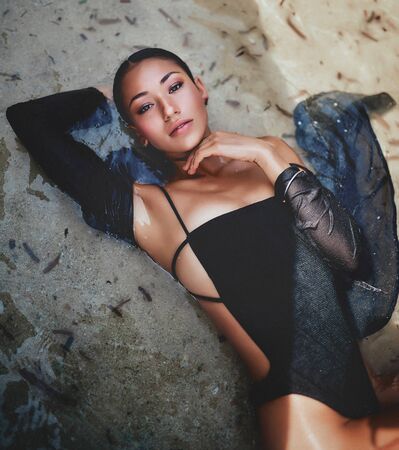 a sexy woman lying in the sea on the beachの写真素材