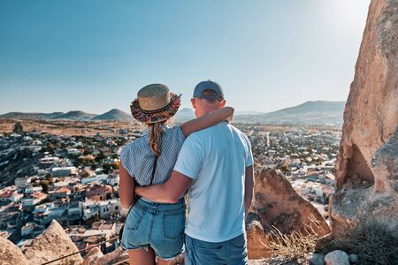 Young couple of travelers on a hill with stunning views of Goreme city in Cappadociaの写真素材