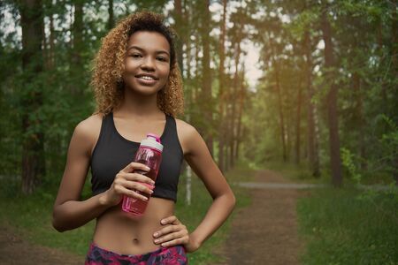 Portrait of black young woman taking break while joggingの写真素材