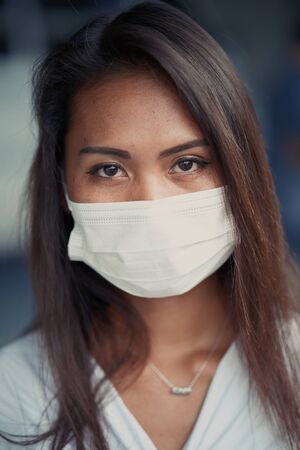 young beautiful Asian woman or hospital nurse using protective medical face mask in prevention vs virus infection.の写真素材