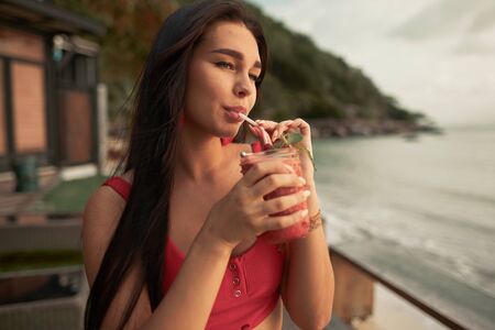 Beautiful young woman drink fruit shake