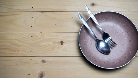 a set of cutlery seen in the picture contained a cutlery and a plate with a wooden background, copy spaceの写真素材