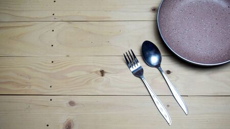 a set of cutlery seen in the picture contained a cutlery and a plate with a wooden background, copy spaceの写真素材