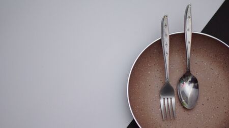 a set of cutlery seen in the picture contained a cutlery and a plate with a black and white...