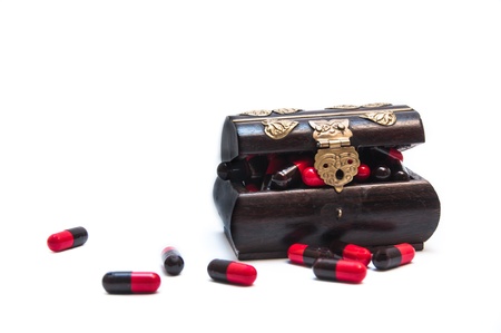 Red-black pills in wooden coffinの写真素材