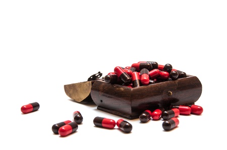 Red-black pills in wooden coffinの写真素材