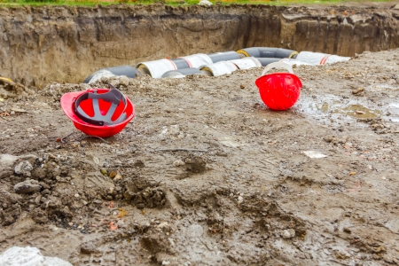 Hard hat on the construction site pipeline on the background