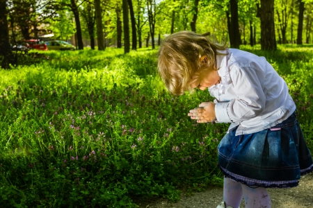 Blond toddler girl with big blue eyes making a funny faces.の写真素材