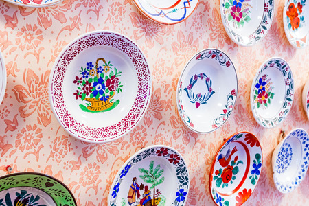 Colored with flower design, ornamental plate is hanging on the wall.の写真素材