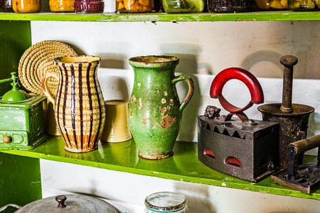 Old vintage kitchen shelves are filled with antique objects.の写真素材