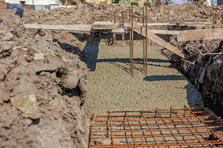 Concrete is flowing over reinforcement at the base of new building.の写真素材