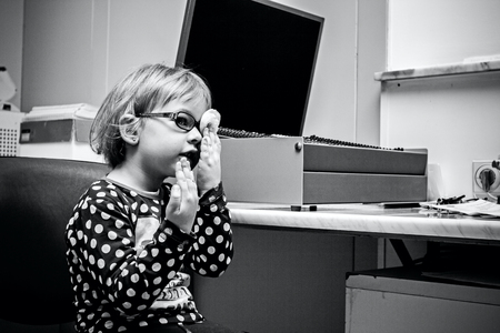 Little girl is at the eye examination showing directions of signs on board.の写真素材