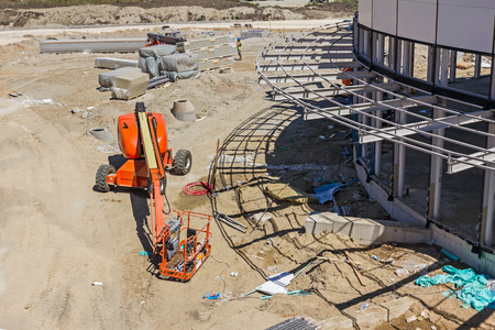 Cherry picker parked next to a newly painted metal frame building.