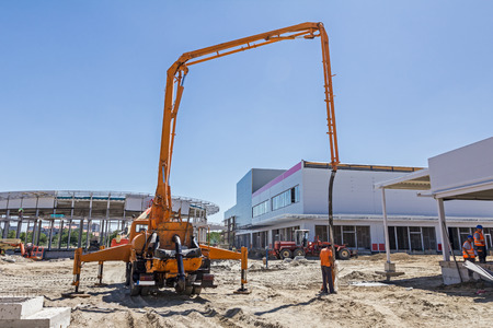 Construction workers are preparing pump for concrete for pouring.