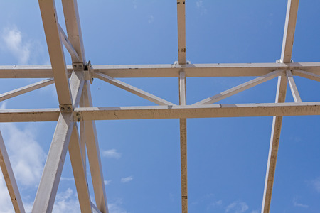 New structure girders on skeleton of the future roof against the blue sky.