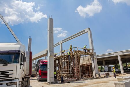 View on building site until workers are assembly a huge mold with reinforcement mesh for concreting.の写真素材