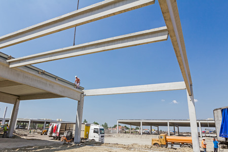 Height worker is high up on concrete frame without proper safety equipment.