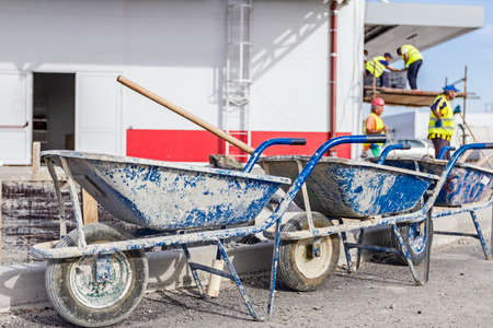 Wheelbarrow at the road works. Workers are resting from cleaning new parking place.の写真素材