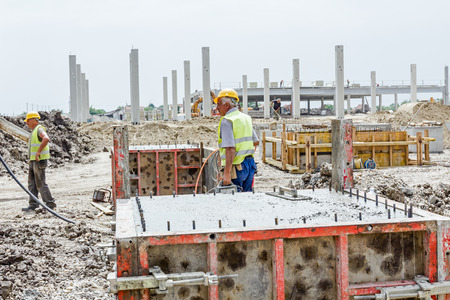 Zrenjanin, Vojvodina, Serbia - May 21, 2015: Workers at building site are pouring concrete in mold from mixer truck.のeditorial素材