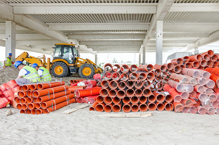 Sewer pipes waiting to be placed into the ditch at construction site.の写真素材