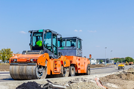 Group of machines for spreading asphalt are parked after road construction at building site.