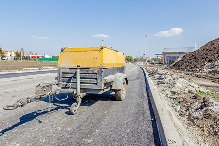 Mobile compressor with a jackhammer parked at building site