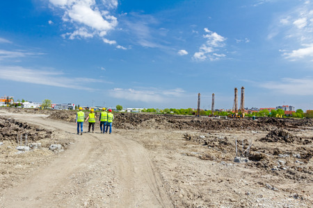 Engineers in hardhats inspecting a work site discussing about work plan.の写真素材