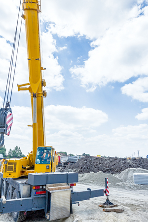 Mobile crane is extracting his arm to start working with heavy loadの写真素材