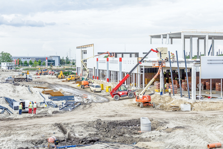 Landscape transform into urban area with machinery, people are working. View on construction site.のeditorial素材