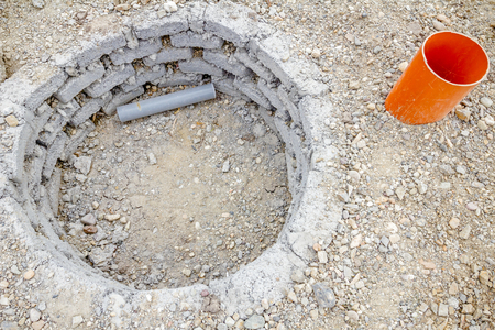 Urban hole coated with bricks and mortar for planting young tree.