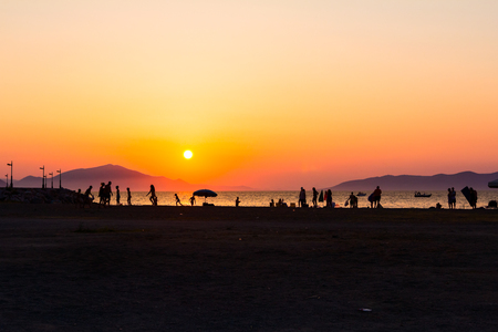 Silhouette of group of friends, young people, until they are having fun on the beach playing soccer.の写真素材