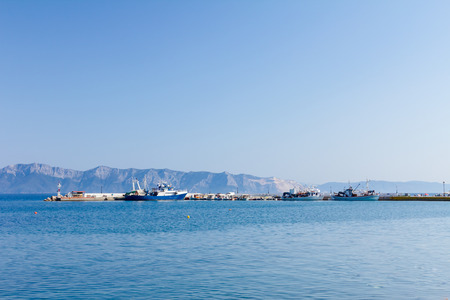 View to the open sea with docked fishing ships tied at local port.の写真素材