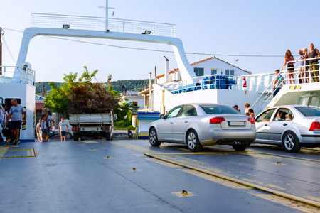 Pefki, Island Evia, Greece - 11, July 2017: Anchored large ferryboat has opened his front entrance for unloading people, tourists and vehicles at the local harborのeditorial素材