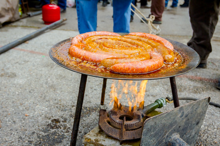 Traditional homemade pork sausages are simmering on barbecue grill, metal griddle.の写真素材