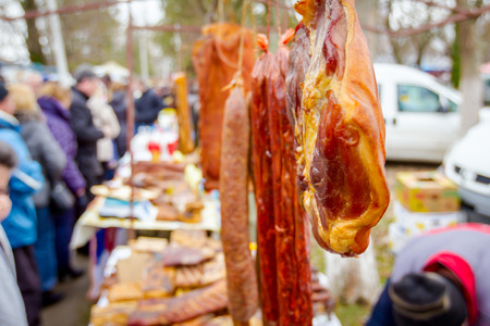 Selling cured meat and sausages, hang for sale at outdoor flea market.の写真素材