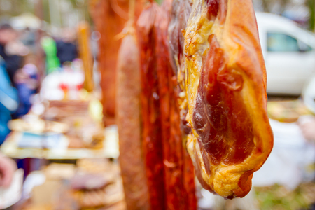 Selling cured meat and sausages, hang for sale at outdoor flea market.の写真素材