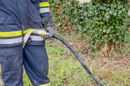Firefighter is helping fellow to assembly water gun on the hose coupler.の写真素材