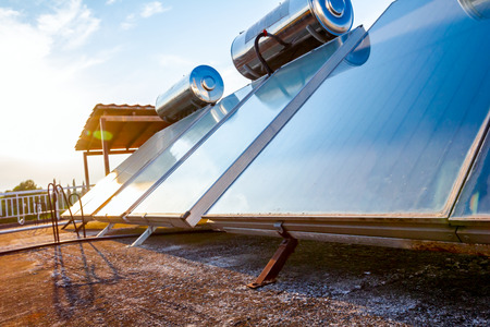 Water panels for using renewable sun energy are placed on house roof, solar hot water system. Modern energy saving technologyの写真素材