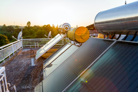 Water panels for using renewable sun energy are placed on house roof, solar hot water system. Modern energy saving technologyの写真素材
