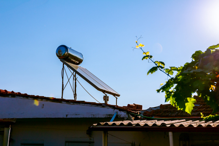 Water panels for using renewable sun energy are placed on house roof, solar hot water system. Modern energy saving technologyの写真素材