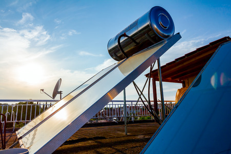 Water panels for using renewable sun energy are placed on house roof, solar hot water system. Modern...