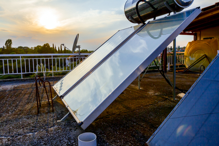 Water panels for using renewable sun energy are placed on house roof, solar hot water system. Modern energy saving technologyの写真素材